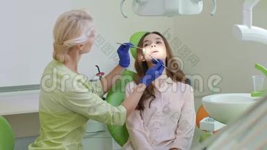 牙科办公室龋齿治疗。 在牙科椅上张开嘴的女人